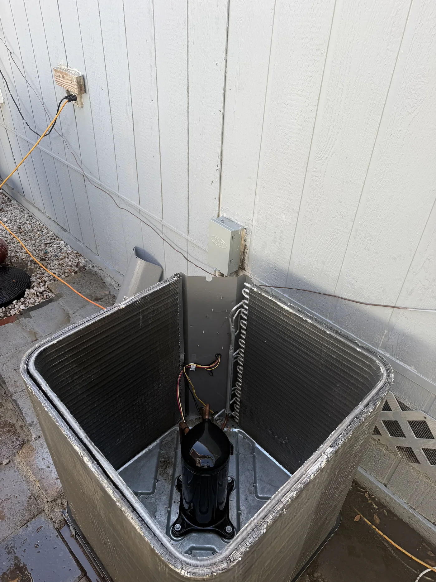 Cleaned outdoor condenser interior with panels removed after rinsing.